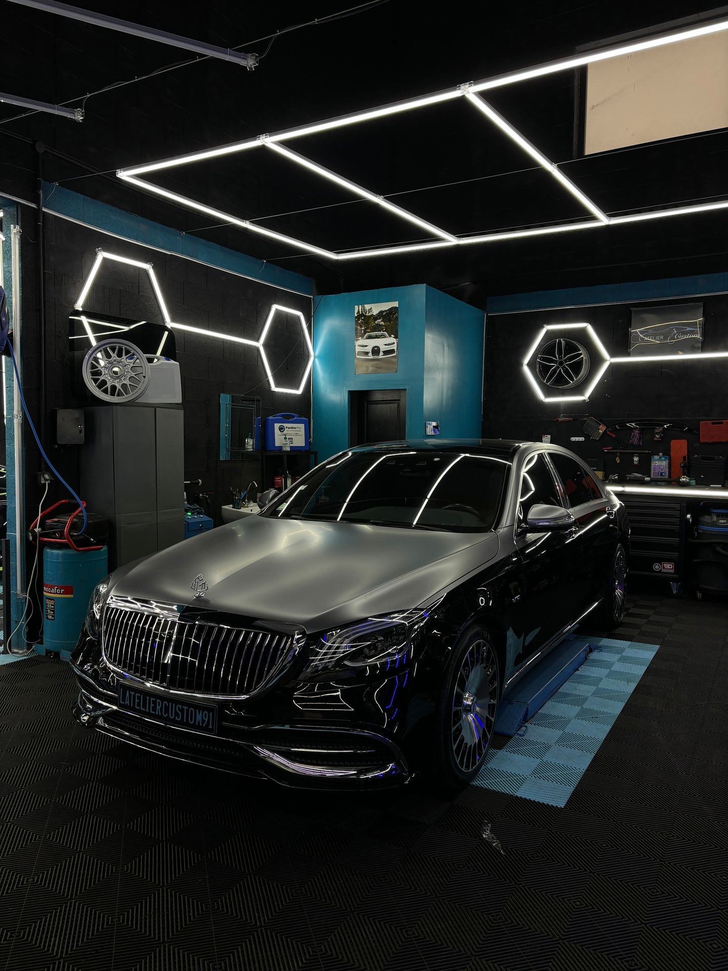 Luxury car in a modern garage with geometric LED lighting and vibrant decor.